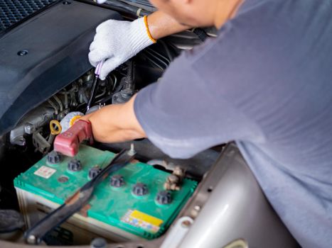 Mechanic holding a block wrench handle while fixing a car.