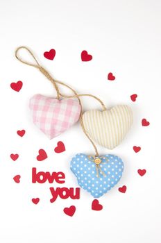 Valentine's day card. Top view cute composition with handmade fabric hearts on white paper background. Happy birthday or anniversary congratulation. Romantic message template with copy space.