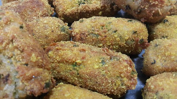 Closeup perspective view of home made spicy and delicious croquettes served with tea or other dishes during parties as fast food.