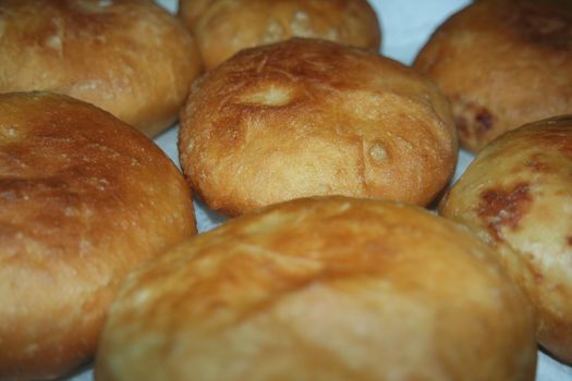 Closeup view of homemade tasty potato bread rolls bun placed over white tissue paper.