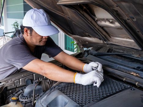 Mechanic holding a block wrench handle while fixing a car.