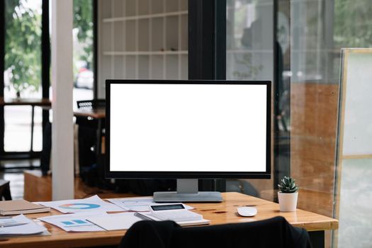 Business workspace with computer blank white screen at office.