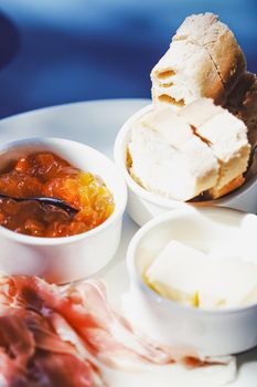 Breakfast outdoors in summer, ham, jam, butter and ham.