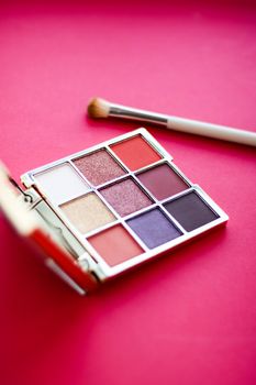 Cosmetic branding, mua and girly concept - Eyeshadow palette and make-up brush on red background, eye shadows cosmetics product for luxury beauty brand promotion and holiday fashion blog design