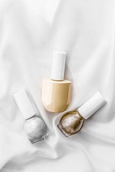 Cosmetic branding, salon and glamour concept - Nail polish bottles on silk background, french manicure products and nailpolish make-up cosmetics for luxury beauty brand and holiday flatlay art design