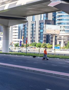 Dubai, UAE - 10.04.2021 Cleaner cleaning parking lots at Sheikh Zayed road