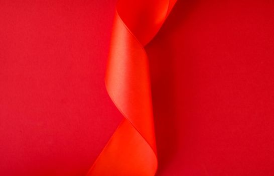 Branding, holidays and luxe brands concept - Abstract curly silk ribbon on red background, exclusive luxury brand design for holiday sale product promotion and glamour art invitation card backdrop