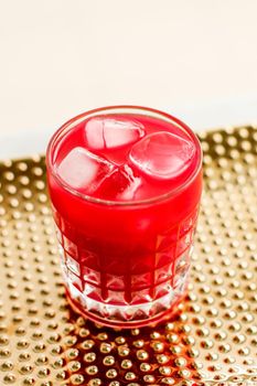 Alcohol drink, refreshment and cold beverage concept - Glass of red cocktail with ice, luxury bar party