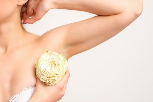 Close up of female armpit with white rose flower isolated on white background