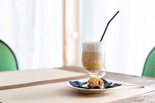 Latte macchiato in tall glass close up. Coffee on a table in cafe