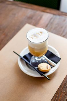 Latte macchiato in tall glass close up. Coffee on a table in cafe