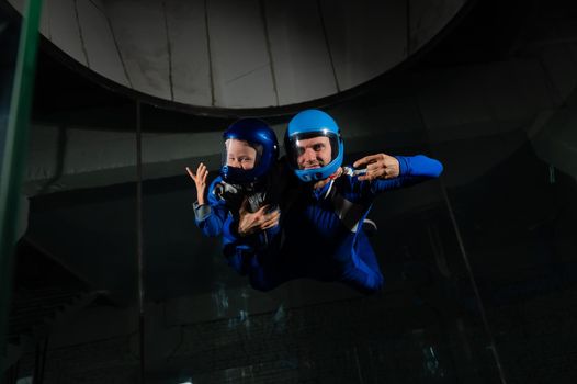 A man teaches a boy to fly in a wind tunnel. Lack of gravity