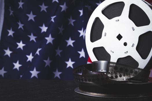 American cinema. Cinematography in the USA. Old film reel on the background of the flag of America.