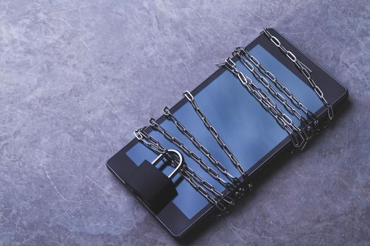 Prohibited applications on a smartphone. Blocking dangerous applications. Bypass blocking with vpn. Phone and chain with lock. Chain around and locked padlock. Limited access to user data.