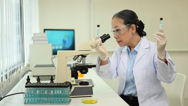 Professional scientist wearing white coat conducting experiment in research laboratory. Scientific research and technology concept.