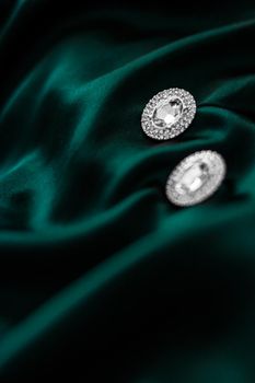 Jewellery brand, elegant fashion and bridal luxe gift concept - Luxury diamond earrings on dark emerald green silk, holiday glamour jewelery present