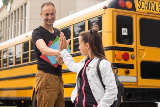 first day at school. father leads a little child school girl in first grade