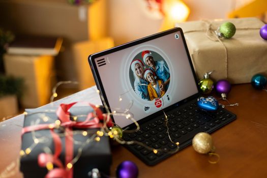 Big family singing christmas song at tablet camera during online video call. Smiling parents and children. Joyful family congratulating relatives with happy new year online.