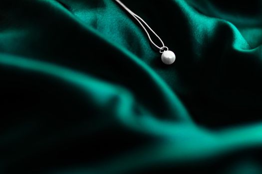 Jewellery brand, elegant fashion and bridal luxe gift concept - Luxury white gold pearl necklace on dark emerald green silk background, holiday glamour jewelery present