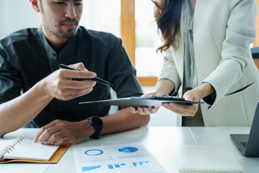 A portrait of a female marketer and a male salesperson discussing how to increase sales by investing in new products to expand marketing using documents and computers in working, new idea product.