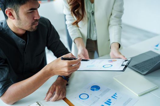 A portrait of a female marketer and a male salesperson discussing how to increase sales by investing in new products to expand marketing using documents and computers in working, new idea product.