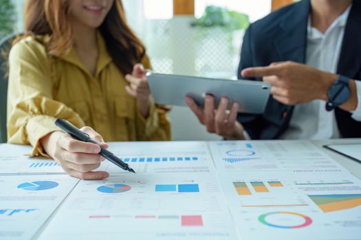A portrait of a female business owner consulting a male salesperson to devise a strategy to increase revenue from new incoming goods using investment budget documents and an analytical computer.