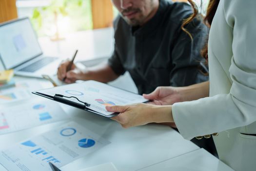 A portrait of a female marketer and a male salesperson discussing how to increase sales by investing in new products to expand marketing using documents and computers in working, new idea product.