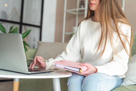 Distance learning online education and work. Business woman with notebook. Cropped freelance girl with laptop at home office. Using computer and online shops. Focus on hand