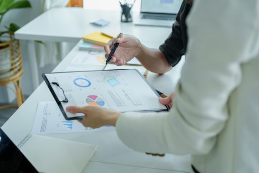 A portrait of a female marketer and a male salesperson discussing how to increase sales by investing in new products to expand marketing using documents and computers in working, new idea product.