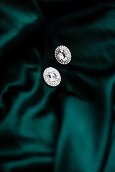 Jewellery brand, elegant fashion and bridal luxe gift concept - Luxury diamond earrings on dark emerald green silk, holiday glamour jewelery present