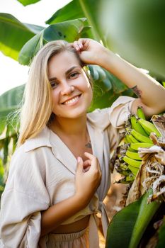 Woman near large green leaf of banana tree on nature in park. Tropical plants