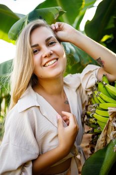 Woman near large green leaf of banana tree on nature in park. Tropical plants