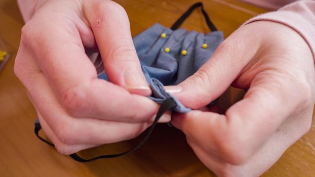 Sewing cotton face mask with a sewing machine for coronavirus outbreak.