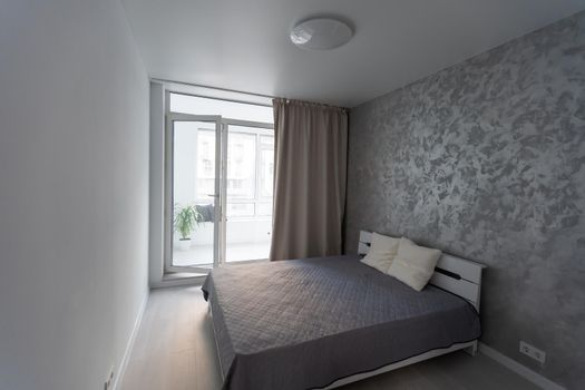 bed with two pillows. gray linen on king size bed. minimalism in hotel.