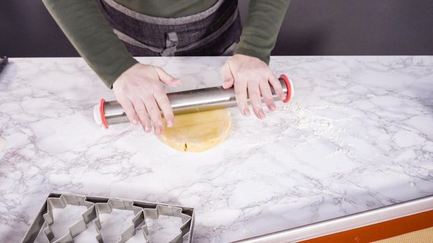 Step by step. Rolling out sugar cookie dough to bake Christmas cookies.