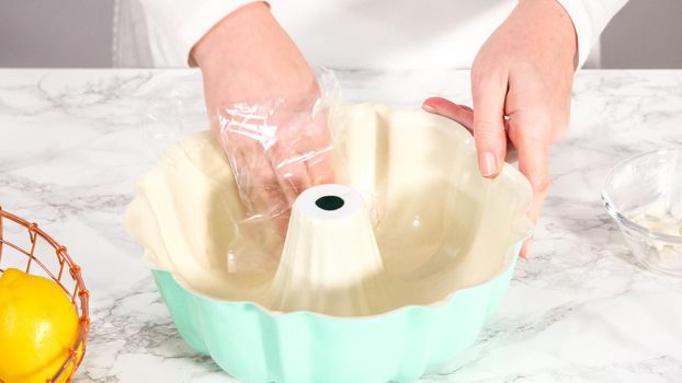 Step by step. Greasing bundt cake pan with vegetable shortening and sprinkling with white flour.