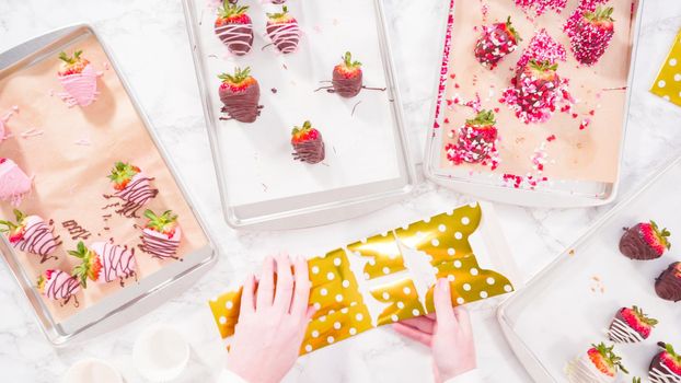 Flat lay. Step by step. Packing gourmet chocolate dipped strawberries into a gift box.