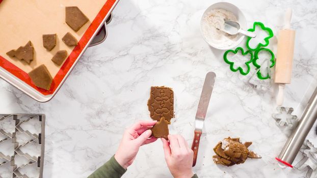 Flat lay. Step by step. Cutting out shapes with Christmas cookies cutter from gingerbread cookie dough.