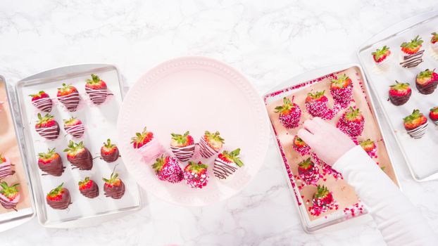 Flat lay. Step by step. Arranging a variety of chocolate dipped strawberries on a pink cake stand.