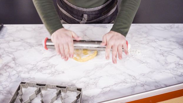 Step by step. Rolling out sugar cookie dough to bake Christmas cookies.