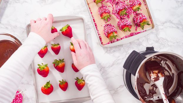 Flat lay. Step by step. Dipping organic strawberries into melted chocolate.