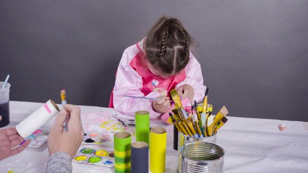 Kids papercraft. Painting empty toilet paper rolls with acrylic paint to create paper bugs.