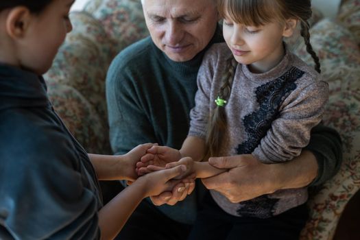 hands of grandfather and granddaughter with prayer.