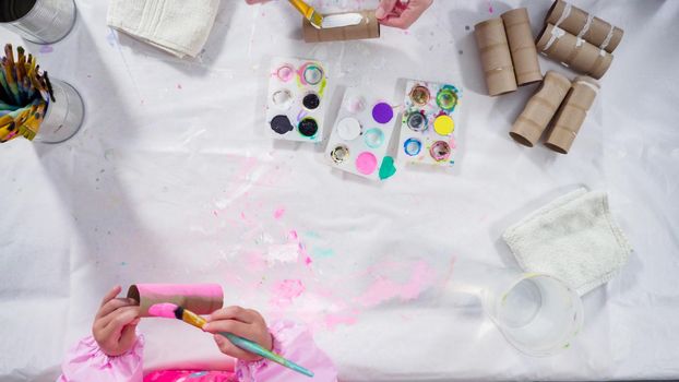Flat lay. Kids papercraft. Painting empty toilet paper rolls with acrylic paint to create paper bugs.