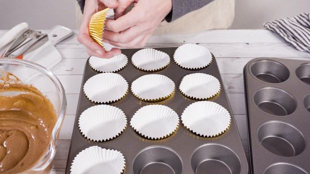 Cupcake pan lined with foil cupcake cups to bake chocolate raspberry cupcakes.