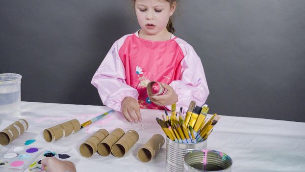 Kids papercraft. Painting empty toilet paper rolls with acrylic paint to create paper bugs.