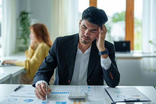 Portrait of a male businessman showing anxiety about making big investments to manage risks in the event of a marketing plan failure, taking financial and investment budget documents to working.