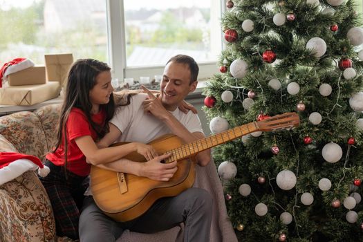 Happy family with guitar in motorhome on Christmas eve.