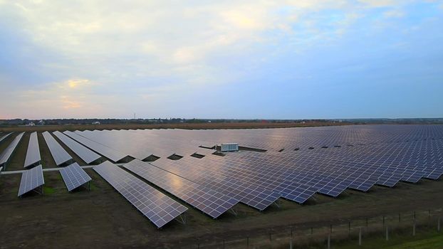 Large solar panels at a solar farm at summer sunset. Solar cell power plants. footage HDR video 4k, aerial drone view