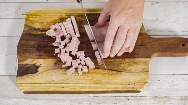 Cutting organic honey ham on a wood cutting board.